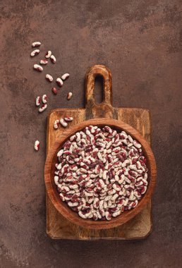 Değişik fasulyeler, beyaz benekli kırmızı, ahşap kasede çiğ, üst manzara, insan yok.,