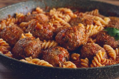 Kıyılmış köfte, domates sosu, fusilli makarna, dökme demir bir tavada, ev yapımı, insan yok.,