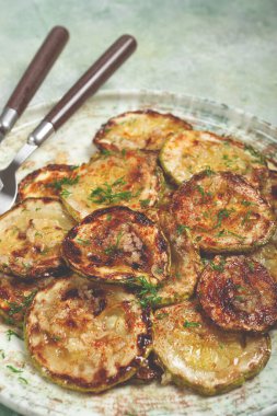 Kızarmış kabak, halka şeklinde kesilmiş, sarımsak ve otlarla, tabakta, üst tarafta, ev yapımı, insan yok.,