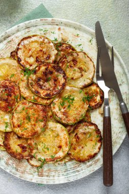 fried zucchini, cut into rings, with garlic and herbs, on a plate, top view, homemade, no people, clipart