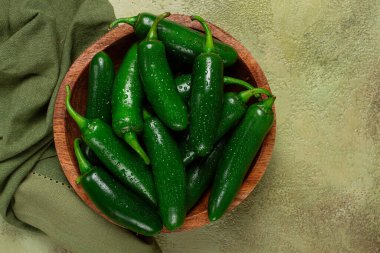 fresh padron pepper, raw, in a wooden bowl, on the table, there are no people. clipart