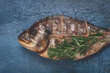 Dorado balığı, sıcak tütsülenmiş, biberiyeli, iple bağlanmış, mavi arka planda, üst tarafta, tütsülenmiş balık, yakın plan, insan yok.,