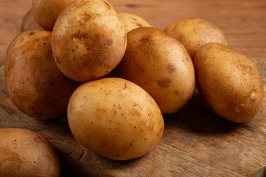 Çiğ patates, doğrama tahtasına saçılmış, yakın plan, insan yok.,