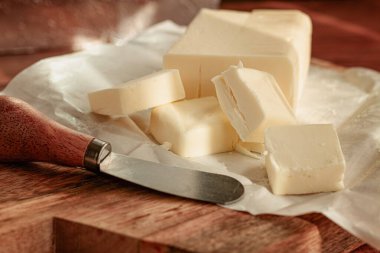 Tereyağı briketi, ambalaj kağıdı, ahşap doğrama tahtası ve tereyağı bıçağı, kahvaltı, köy tarzı, insan yok.,