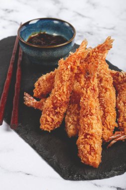 Tempura 'da karides, yağda kızartılmış, siyah tahtada, soslu, açık mermer masa, insan yok.,