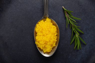 İnci yuzu, yuzu havyarı. Koyu gri bir tabakta, kaşığın üstünde inci. Hiç insan yok..