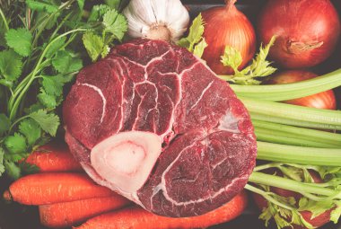 Kemiklerdeki eklem, ossobuko için çiğ et, sebzeli, sepetli, ossobuko pişirmek için malzemeler, üst manzara, insan yok.,