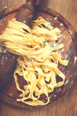 Çiğ tagliatelle makarna, ev yapımı, merdane, üst görünüm, kesim tahtası, pişirme konsepti.,