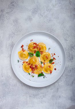 Taze ravioli, tereyağlı, baharatlı ve otlu, kızarmış pastırmalı, masada, üst tarafta, arka planda, insan yok.,