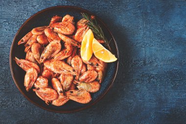 Kabuklu ve başlı kızarmış karides, soyulmamış, 70-90 numara, mavi arka planda, ev yapımı, insan yok.,