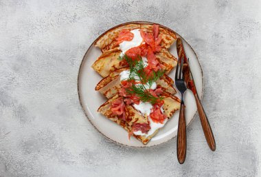 Somon ve ekşi kremalı leziz gözlemeler, kahvaltı tabakta, kırsal tarzda, çatal bıçaklı.