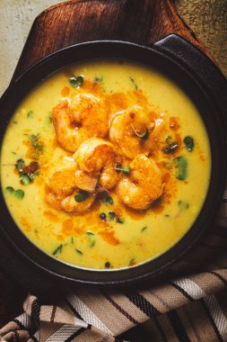Baharatlı kremalı karides körisi, otlarla süslenmiş, dokulu arka planda, ev yapımı, insan yok.,