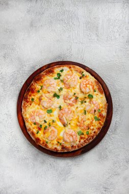 Dört peynirli karides ve taze mikro yeşil pizza, ahşap bir tahtanın üzerinde servis ediliyor, ev yapımı, insan yok.,