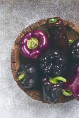 assortment of bell peppers, purple and black peppers, in a wooden bowl, top view, no people, clipart