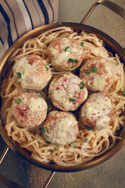 Tavuk köfteli spagetti, krema soslu, ve parmesan peyniri, ve mikro yeşillikle süslenmiş, ev yapımı, insan yok.,