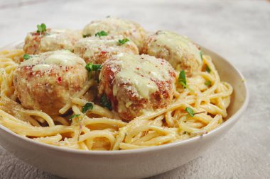 Tavuk köfteli spagetti, krema soslu, ve parmesan peyniri, ve mikro yeşillikle süslenmiş, ev yapımı, insan yok.,