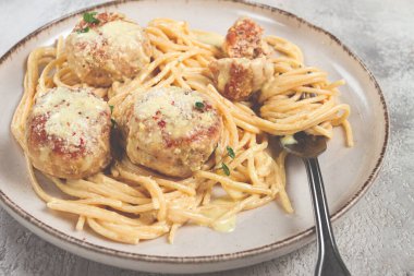 Tavuk köfteli spagetti, krema soslu, ve parmesan peyniri, ve mikro yeşillikle süslenmiş, ev yapımı, insan yok.,