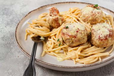 Tavuk köfteli spagetti, krema soslu, ve parmesan peyniri, ve mikro yeşillikle süslenmiş, ev yapımı, insan yok.,