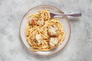 Tavuk köfteli spagetti, krema soslu, ve parmesan peyniri, ve mikro yeşillikle süslenmiş, ev yapımı, insan yok.,