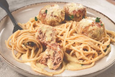 Tavuk köfteli spagetti, krema soslu, ve parmesan peyniri, ve mikro yeşillikle süslenmiş, ev yapımı, insan yok.,