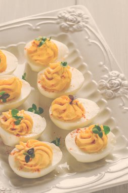 Haşlanmış yumurta sarısı, mayonez ile doldurulmuş, beyaz tabakta, seçici odak, bulanık, yakın plan, insan yok.,