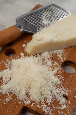 Taze dilimlenmiş ve rendelenmiş peynir, parmesan peyniri, büyük anne hazzı. Grana padano. Ahşap kesim tahtasının üzerinde, köylü tarzı, insan yok.