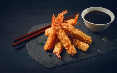 Tempura 'da karides, bol yağda kızartılmış, siyah tahtada, soya soslu, yatay, insan yok.,