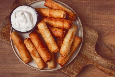 Peynirli kızarmış börek, ahşap bir arka planda, krema soslu, insan yok.,