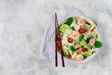 Karides ve pirinç erişteli Tayland salatası, ananas dilimleri, kişniş ve nane yaprakları, beyaz tabakta, ev yapımı, insan yok.,
