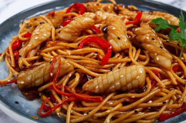 Udon eriştesi, kalamar ve sebzeli, mermer bir masada, ev yapımı, insan yok.,