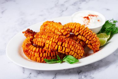 Mısır pirzolası, krema soslu, baharatlı ve limonlu, aperatif, beyaz tabakta, ev yapımı, insan yok.,