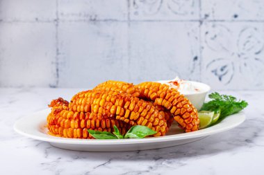 Mısır pirzolası, krema soslu, baharatlı ve limonlu, aperatif, beyaz tabakta, ev yapımı, insan yok.,