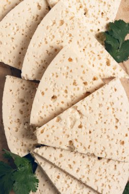 Dilimlenmiş Gürcistan peyniri, fabrika kalitesinde, ahşap bir tahtanın üstünde.,