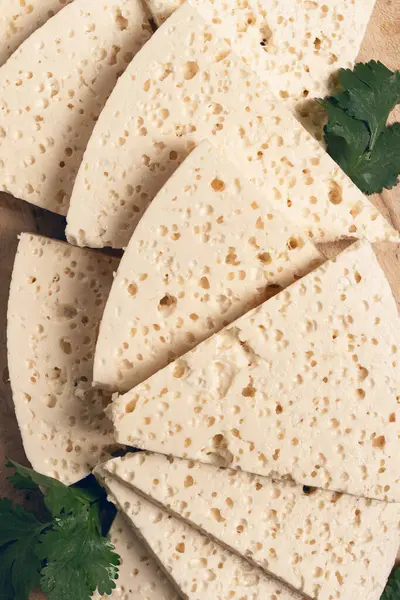 Dilimlenmiş Gürcistan peyniri, fabrika kalitesinde, ahşap bir tahtanın üstünde.,