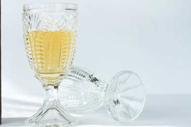 Beyaz şarapla dolu kristal bardak, zarif tasarım, parlak bir ortamda, yakın plan, seçici odak, insan yok.,