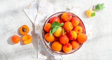 Kasede taze kayısılar, parlak bir masada, doğal ışık, üst manzara, insan yok.,