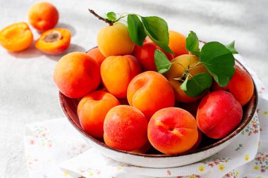 Kasede taze kayısılar, parlak bir masada, doğal ışık, üst manzara, insan yok.,