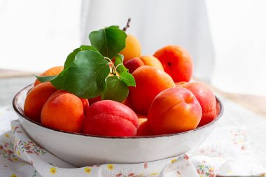 Kasede taze kayısılar, parlak bir masada, doğal ışık, üst manzara, insan yok.,