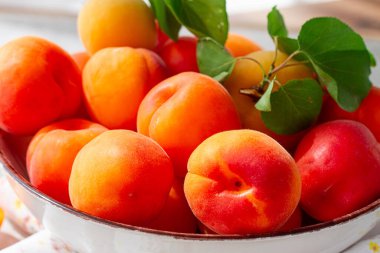 Kasede taze kayısılar, parlak bir masada, doğal ışık, üst manzara, insan yok.,