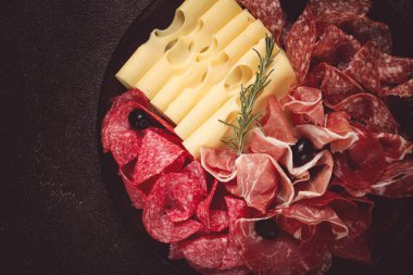 Pirzola, aperatif, prosciutto, salam ve jambon, maasdam peyniri ve zeytinli, yuvarlak tabakta, kahvaltı, üst manzara, yakın çekim, terk edilmiş