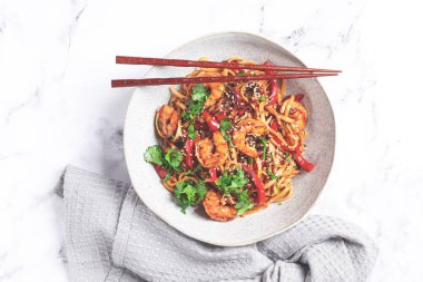 udon eriştesi, sebzeli ve taze otlu karides, çubuklu bir kâse, hafif arka plan, ev yapımı, insan yok.,