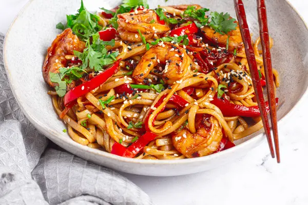 udon eriştesi, sebzeli ve taze otlu karides, çubuklu bir kâse, hafif arka plan, ev yapımı, insan yok.,