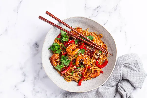 udon eriştesi, sebzeli ve taze otlu karides, çubuklu bir kâse, hafif arka plan, ev yapımı, insan yok.,