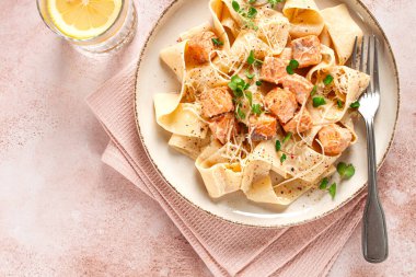 tagliatelli makarna, somon dilimleri ve otlarla dekoratif bir tabakta, ev yapımı, insan yok.