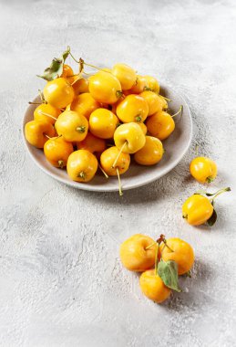 Sarı küçük elmalar, Çin çeşitleri, gri bir tabakta, üst manzara, insan yok.,