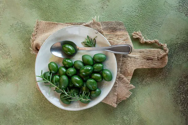 Chalkidiki zeytinleri, klasik Yunan yeşil zeytinleri, bir tabakta, kaşık, üst manzara, insan yok.,