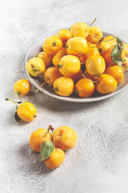 Sarı küçük elmalar, Çin çeşitleri, gri bir tabakta, üst manzara, insan yok.,