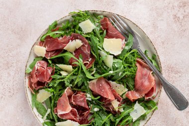 Prosciutto ve rendelenmiş parmesan peynirli taze roka salatası, tabakta, ev yapımı, insan yok.,