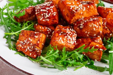 Kızarmış somon dilimleri, susamlı teriyaki roka salatası, en iyi manzara.,