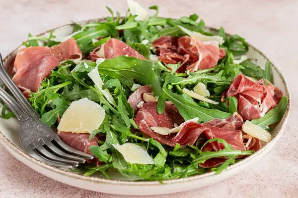 Prosciutto ve rendelenmiş parmesan peynirli taze roka salatası, tabakta, ev yapımı, insan yok.,